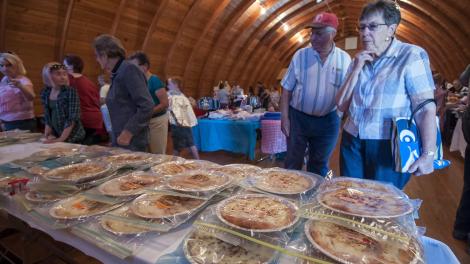 Perusing a variety of pies entered in a competition in Delmont, South Dakota