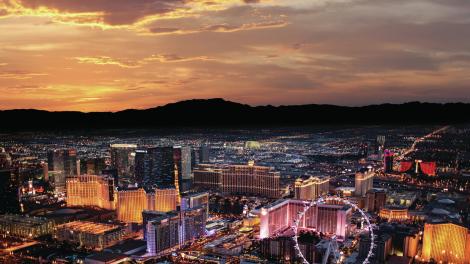 Sunrise over the Las Vegas Strip, framed by a mountainous landscape