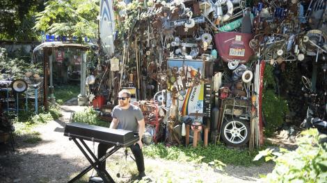 Musician Dr. Joe playing the keyboard in "The Cathedral of Junk," a backyard art project in Austin, Texas