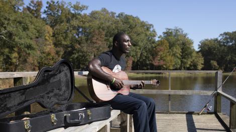 Cedric Burnside taking a break from fishing to play guitar in Jackson, Mississippi