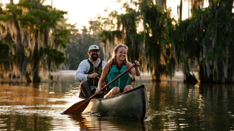 Couple canoeing alongside cypress trees on Lake Martin Couple canoeing alongside cypress trees on Lake Martin