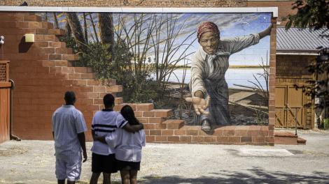 Family viewing a mural featuring Harriet Tubman by Michael Rosato in Dorchester County, Maryland