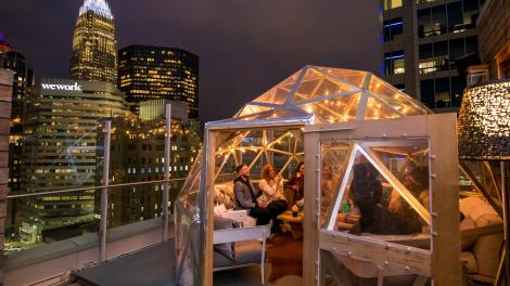 Enjoying a rooftop happy hour with views of downtown Charlotte at Merchant & Trade Enjoying a rooftop happy hour with views of downtown Charlotte at Merchant & Trade