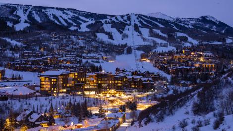 Aerial view of Snowmass Base Village in Colorado with its mountain backdrop at twilight Aerial view of Snowmass Base Village in Colorado with its mountain backdrop at twilight