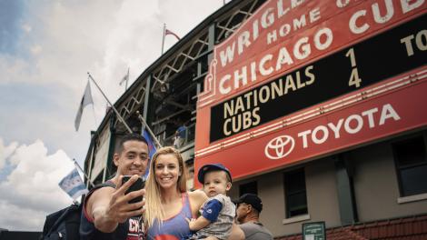 Visitors taking a selfie in front of the iconic marquee of Wrigley Field in Chicago, Illinois  Visitors taking a selfie in front of the iconic marquee of Wrigley Field in Chicago, Illinois
