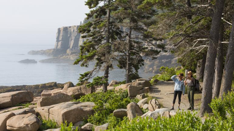 公園管理員和健行者停下腳步欣賞阿卡迪亞國家公園的美景