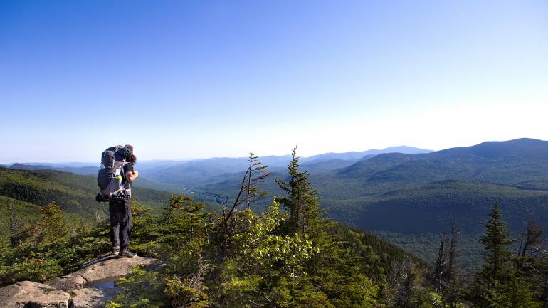 沿著弗蘭科尼亞山峽州立公園鄉間步道健行的背包客