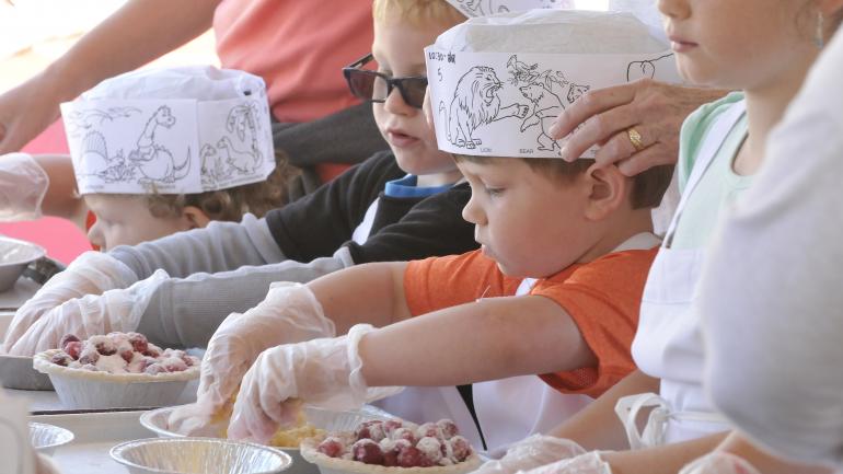 兒童在全國櫻桃節中製作自己的櫻桃派 兒童在全國櫻桃節中製作自己的櫻桃派