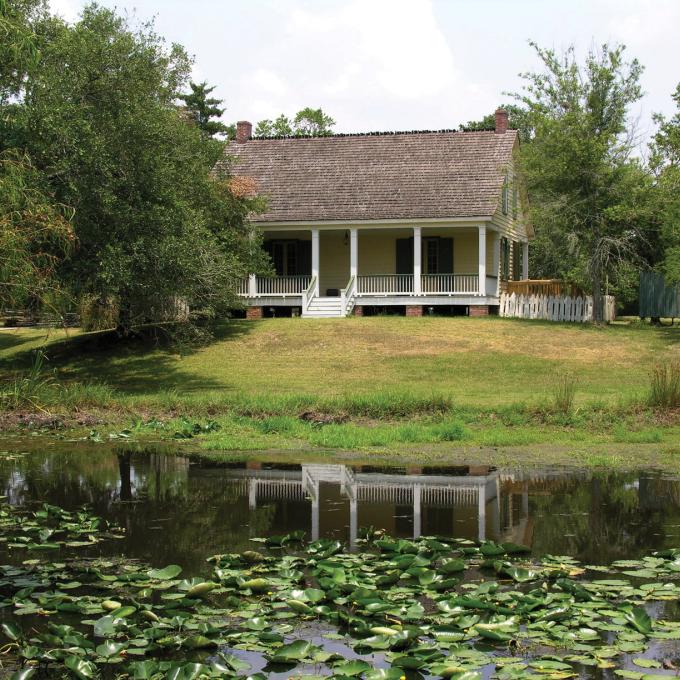 Lily pads float in a pond in front of a country house in Vermilionville Lily pads float in a pond in front of a country house in Vermilionville
