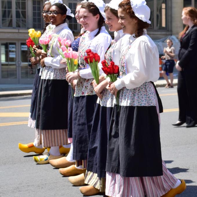 High school students wearing traditional Dutch apparel carry tulips in a parade High school students wearing traditional Dutch apparel carry tulips in a parade