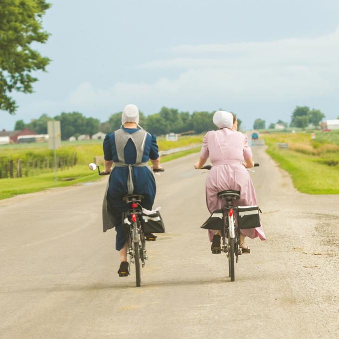 Members of the Amish community in Arthur, Illinois bike through verdant farmlands