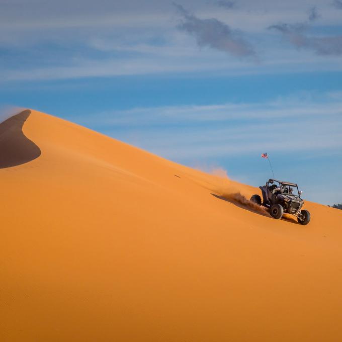 Driving a dune buggy in Coral Pink Sand Dunes State Park in Kanab, Utah Driving a dune buggy in Coral Pink Sand Dunes State Park in Kanab, Utah