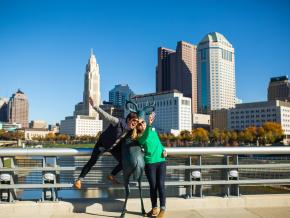 Posing with a deer sculpture in front of the city skyline on the Scioto Mile