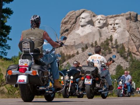 Presidents looking down on cyclists during Sturgis Motorcycle Rally