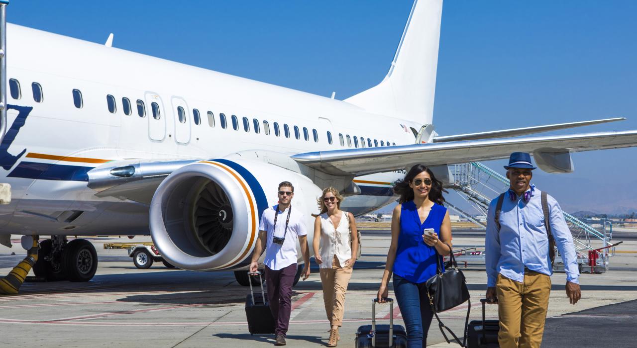 People with luggage disembarking from plane