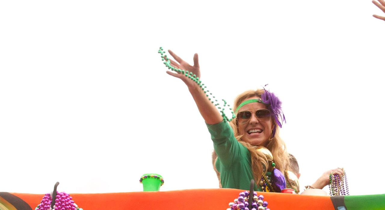 Throwing beads to the crowd at the Mardi Gras parade