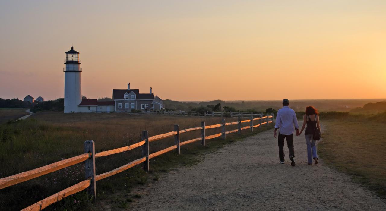 A couple enjoys a sunset stroll at Race Point Light