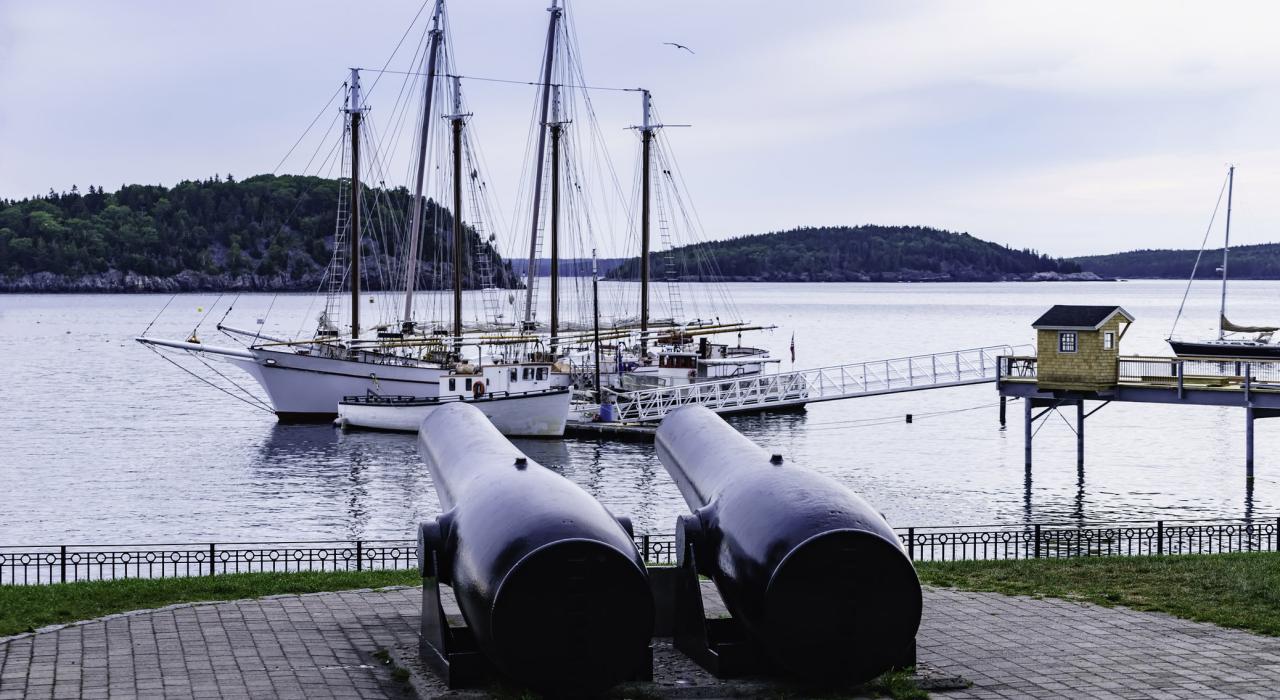 Sailboats under the watch of antique cannons decorating a public square