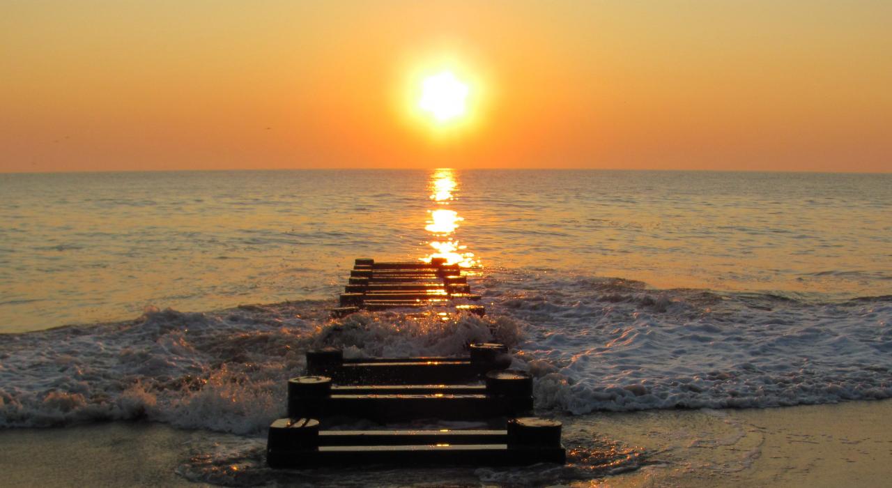 夕陽餘暉中浪花湧上廢棄碼頭 夕陽餘暉中浪花湧上廢棄碼頭