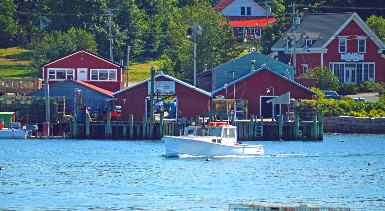 Lobster boat cruising by a fishing village
