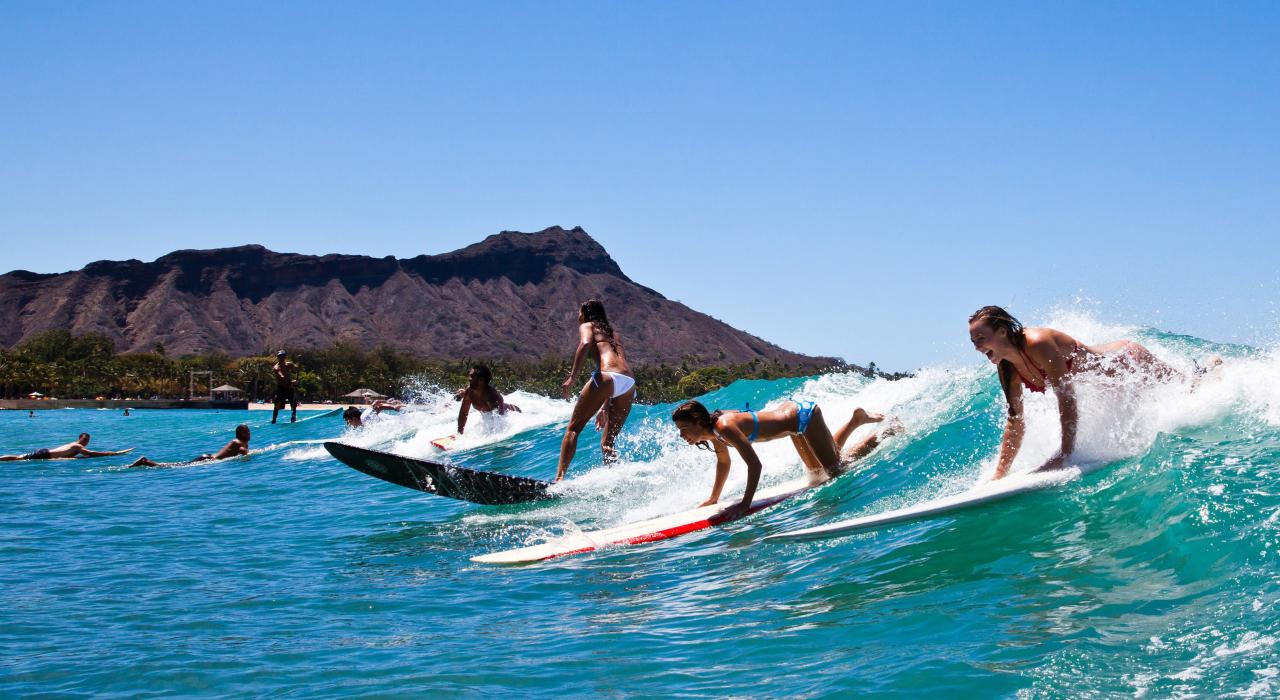 Surfing the clear blue waters of Waikīkī Beach