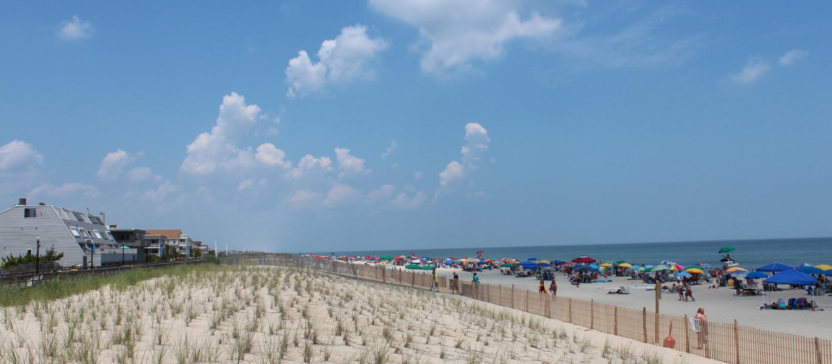 成排的陽傘和遊人家庭齊聚大西洋岸貝瑟尼海灘 成排的陽傘和遊人家庭齊聚大西洋岸貝瑟尼海灘