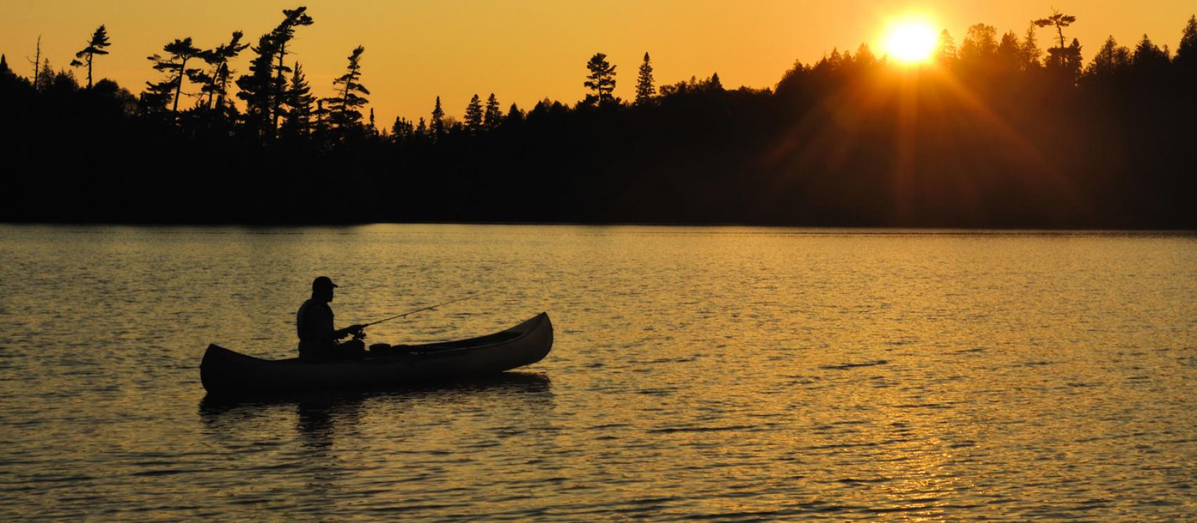 黃昏時分在邊境水域乘獨木舟垂釣