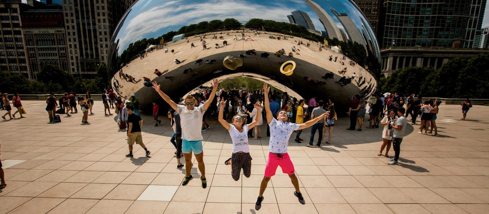 在芝加哥千禧年公園的「豆子」雕塑前方躍起