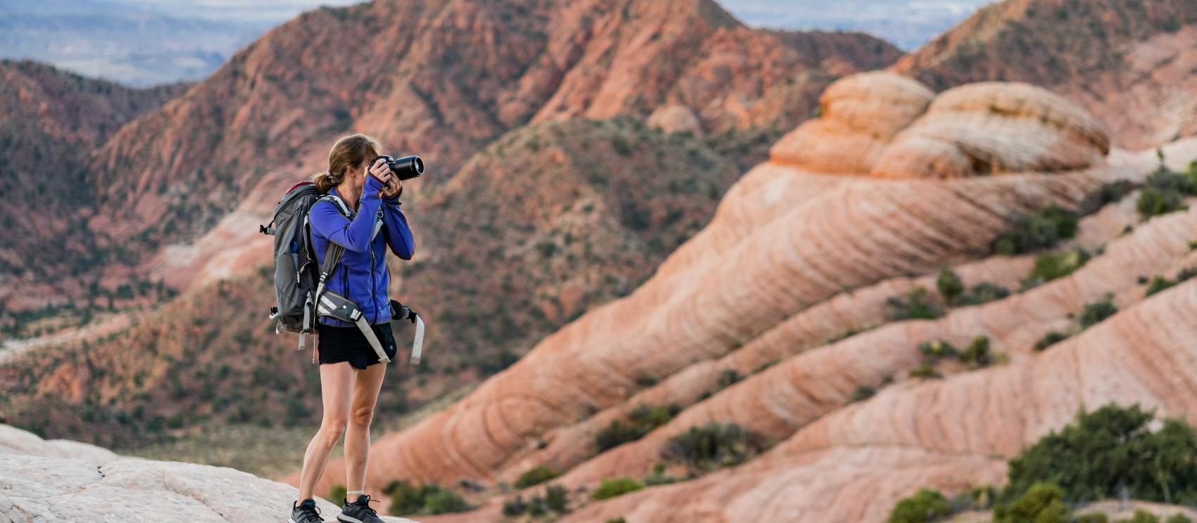 A hiker photographing the multi-colored Yant Flat formations near St. George