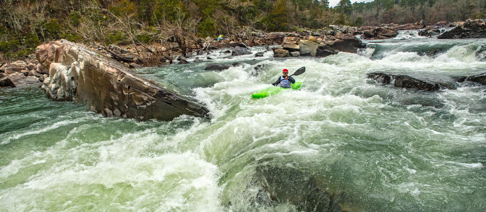 Kayaking through whitewater rapids at Cossatot River State Park-Natural Area Kayaking through whitewater rapids at Cossatot River State Park-Natural Area