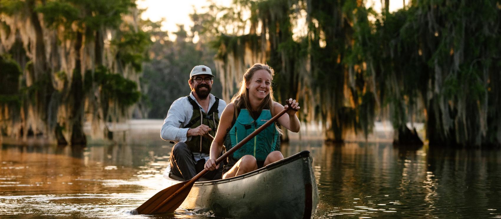 Couple canoeing alongside cypress trees on Lake Martin